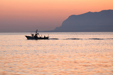 Obraz premium at dawn, a fishing boat goes out to sea. EDITORIAL USE ONLY