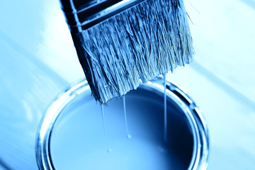 Blue paint is dripping from brush into open can on freshly painted wooden background. Renovation concept. Macro. - 308501962