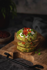 vegetable cutlets are stacked on a wooden board
