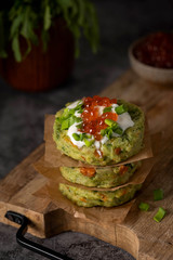 vegetable cutlets are stacked on a wooden board