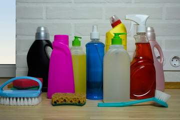 household chemicals in kitchen on background tiles