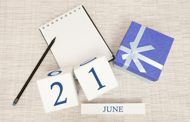 Calendar with trendy blue text and numbers for June 21 and a gift in a box.