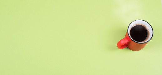 Red Cup with coffee on a light green background.