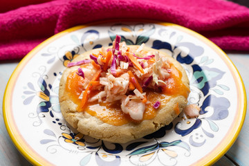 Salvadoran pupusas with coleslaw and tomato sauce on wooden background