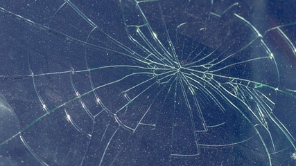 Dark glass with cracks in all directions. Broken glass.