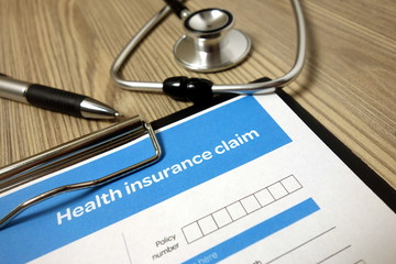 Health insurance claim form mockup with pen and stethoscope