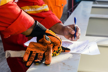 A supervisor signed a pre-job checklist on board a construction work barge prior to heavy lift activity at oil field
