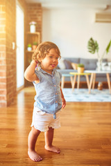 Beautiful toddler child girl wearing blue denim shirt standing on the floor