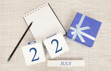 Calendar with trendy blue text and numbers for July 22 and a gift in a box.