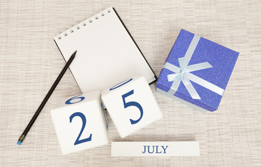 Calendar with trendy blue text and numbers for July 25 and a gift in a box.