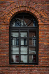 A black window on an old brick wall