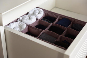 Pink vintage drawer organizer filled with underwears and socks.
