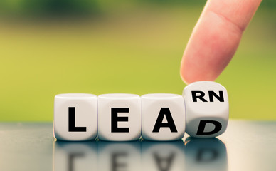 Learn and Lead. Hand turns a dice and changes the word 