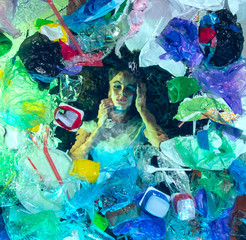 Woman drowning in water under plastic recipients pile, garbage. Used bottles and packs filling world ocean killing people. Ecology, environment concept, plastic and glass pollution, nature disaster.