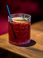 Rotes Getränk mit Zitrone und Strohhalm 
