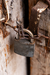 Old padlock on closed wooden door. Old wooden door with lock. 