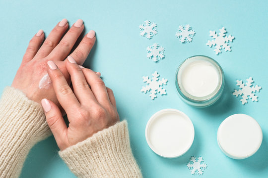 Woman using winter cream for hands.