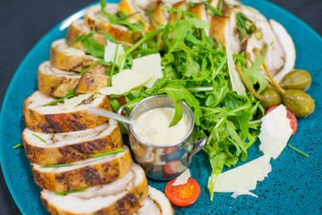 Meatloaf with cream sauce and greens, green leaves of lettuce, top view. Chicken roll flat lay