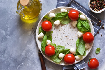 Classic caprese salad with baby mozapela and cherry tomatoes. Christmas wreath - caprese salad. Celebration.