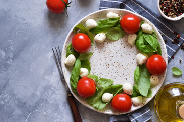 Classic caprese salad with baby mozapela and cherry tomatoes. Christmas wreath - caprese salad. Celebration.