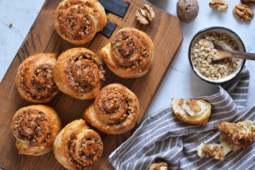 Snail buns with cinnamon and nuts on a concrete background.