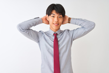 Chinese businessman wearing elegant tie standing over isolated white background relaxing and stretching, arms and hands behind head and neck smiling happy