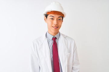Chinese architect man wearing coat and helmet standing over isolated white background with a happy and cool smile on face. Lucky person.