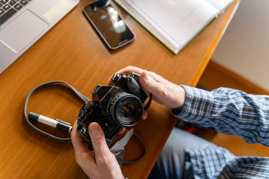 Senior man at home holding camera