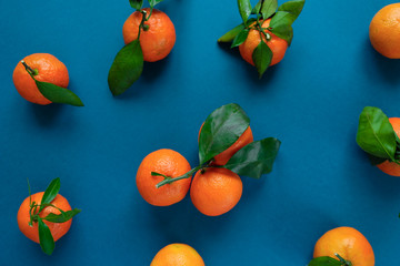 Orange tangerine with leaves on an blue classic background