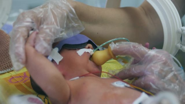 Pacifier is being given to a toddler in a medical box