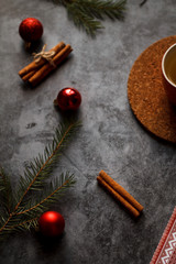 Christmas background. Christmas decorations, holiday decorations, fir branches, red balls, cinnamon and red Lollipop cane on dark stone background top view. 