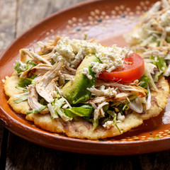 Yucatecan salbutes with chicken meat on wooden background