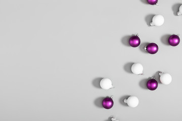 Christmas modern composition. Xmas white and purple decorations on gray background. New Year, winter concept. Flat lay, top view, copy space
