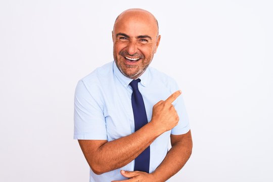 Middle age businessman wearing tie standing over isolated white background cheerful with a smile of face pointing with hand and finger up to the side with happy and natural expression on face
