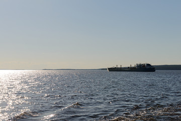 Cargo ship sailing the river on a summer evening