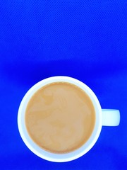  close-up of festive multicolored abstract cup with hot drink on isolated blue background