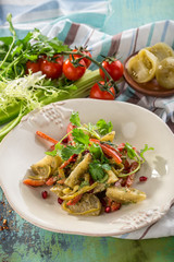 Grilled vegetables warm salad with zucchini, potato, onion, pepper and tomatoon colorful wooden table