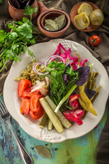 Pickled vegetables cucumber, tomato, garlic, pepper Preserved food on colorful wooden table