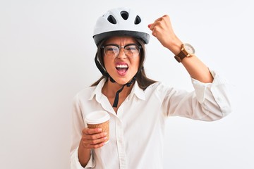 Beautiful businesswoman wearing bike helmet drinking coffee over isolated white background annoyed and frustrated shouting with anger, crazy and yelling with raised hand, anger concept