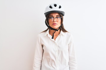 Beautiful businesswoman wearing glasses and bike helmet over isolated white background Relaxed with serious expression on face. Simple and natural looking at the camera.