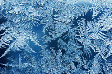 Frosty pattern on the window close-up. Winter background, classic blue texture.