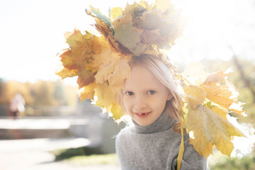 Portrait of smiling little girl with autumn wreath on her head