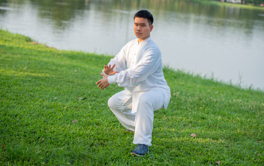 Tai Chi Chuan (Taijiquan) Master man workout on the park, Healthcare with Chinese martial arts  concept.