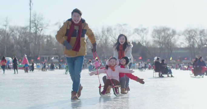 Happy young family having fun on ice,4K