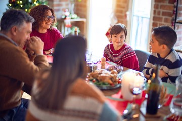 Beautiful family smiling happy and confident. Eating roasted turkey celebrating christmas at home