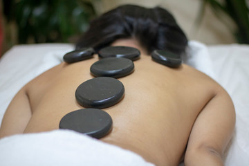 Obraz na płótnie Canvas Back massage with hot stones. Horizontal photo