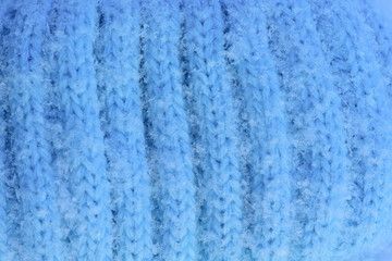 Fototapeta na wymiar snowflakes on wool knitted hat blue. close up