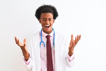 Young african american doctor man wearing sthetoscope over isolated white background celebrating mad and crazy for success with arms raised and closed eyes screaming excited. Winner concept