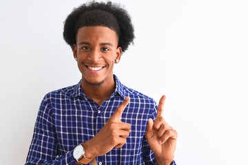 Young african american man wearing casual shirt standing over isolated white background smiling and looking at the camera pointing with two hands and fingers to the side.