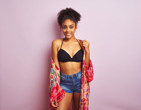 Young beautiful african american woman on vacation standing wearing bikini and colorful caftan